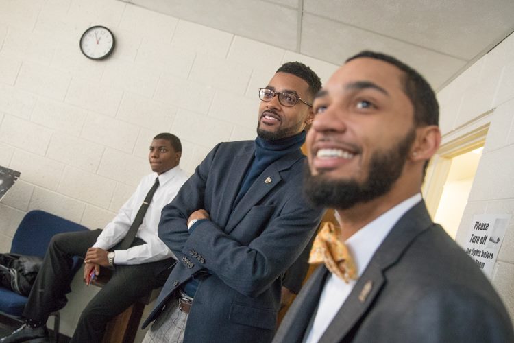 Isaiah Oliver and Jeremiah White, both Alpha Phi Alpha fraternity brothers, look on as mentors to the Alpha Esquires as they prepare for a performance.