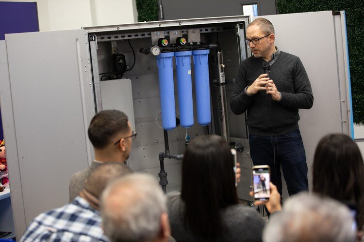 Jaron Rothkop, 501cThree’s head engineer, explains the four-step filtration system of the Water Box to residents at the Latinx Technology and Community Center on Monday, Dec. 2. 