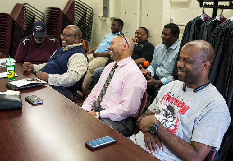 Adult advisors including Robert Matthews (left in blue vest) and 67th District Court Judge David Guinn (front, center) observe the young men of the Alpha Esquires from the back of the room during a meeting earlier this month at the Mott Community Col
