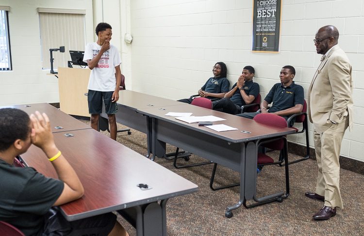 Advisor Sam Wells (right) of Flint Township conducts the Alpha Esquires meeting earlier this month. The group is celebrating its 20th year.