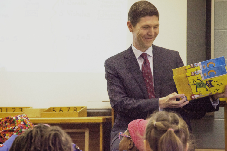 Chester Spellman, director of AmeriCorps for the Corporation for National and Community Service, reads a book to students at Durant-Tuuri-Mott Elementary School in Flint.