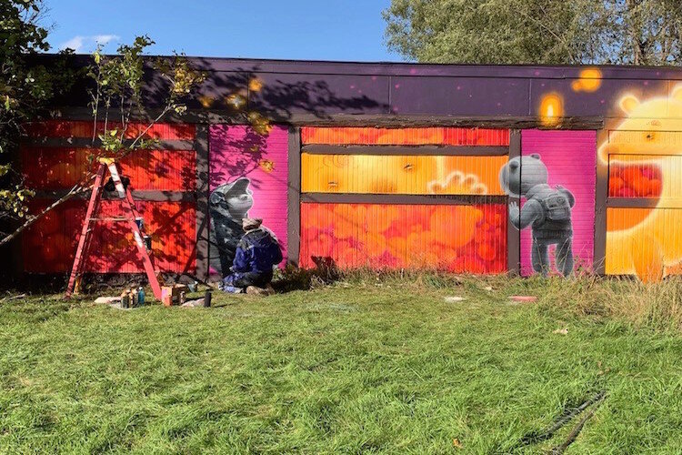 Muralist AnimalitoLand paints the wall of a building at 412 W. Oakley St. during the Free City Mural Festival on Oct. 12, 2019.