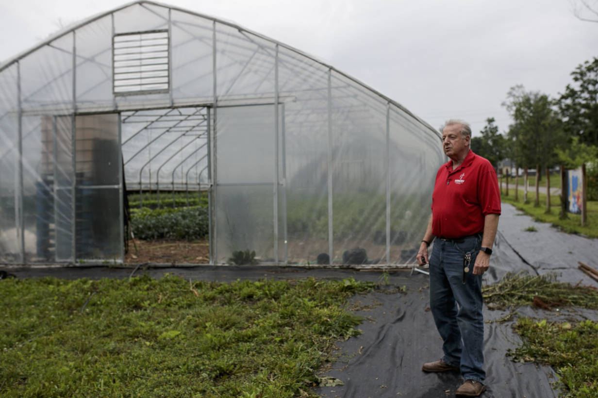 Rev. McDoniel stands outside one of the hoop houses at Asbury Farms.