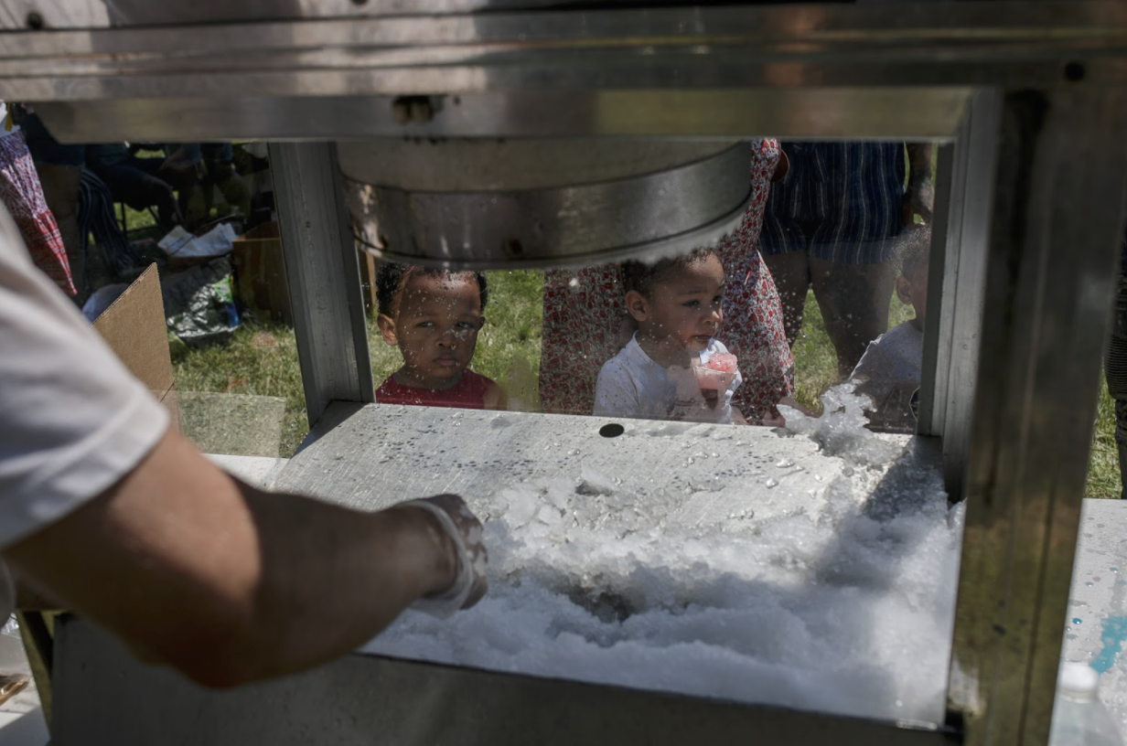 Children wait in line for snow cones during a barbecue on June 5 in Amos Park.
