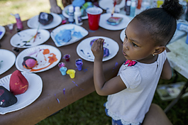 Layla Smith, 4, paints in a crafting area during a community event at Amos Park on June 5.