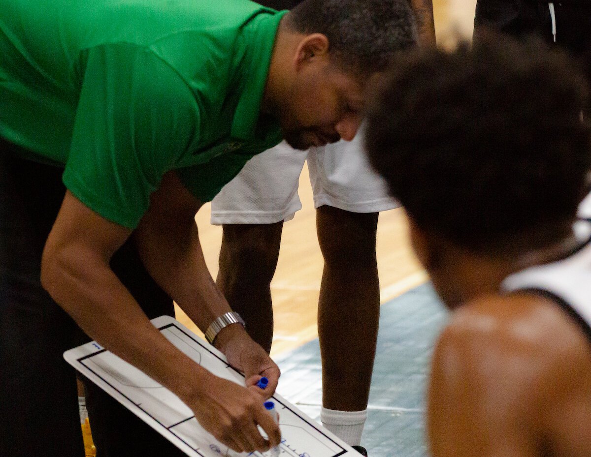 Flint United coach Charlie Bell draws up a play.