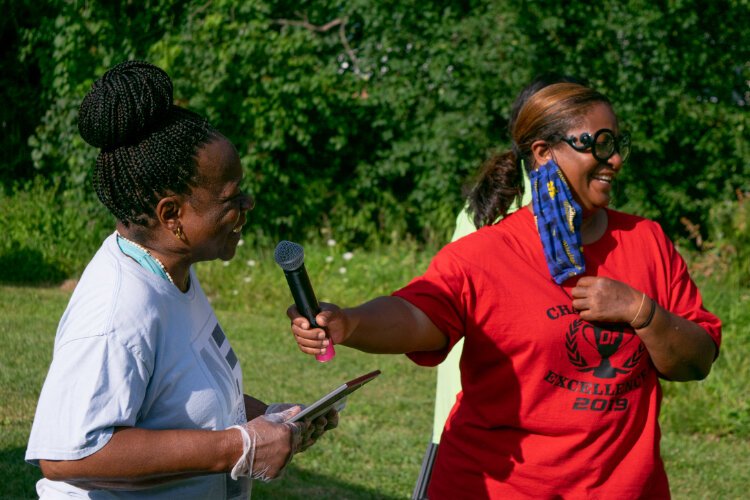 Nancy Kimble receives a certificate of appreiciation and a gift card from Sandra Johnson, Project Manager of the Illuminating Communities project.