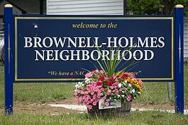 The Brownell-Holmes welcome sign stands on the corner of Home and Oxley. In front of it sits one of the many flower baskets that lines the neighborhood's streets.