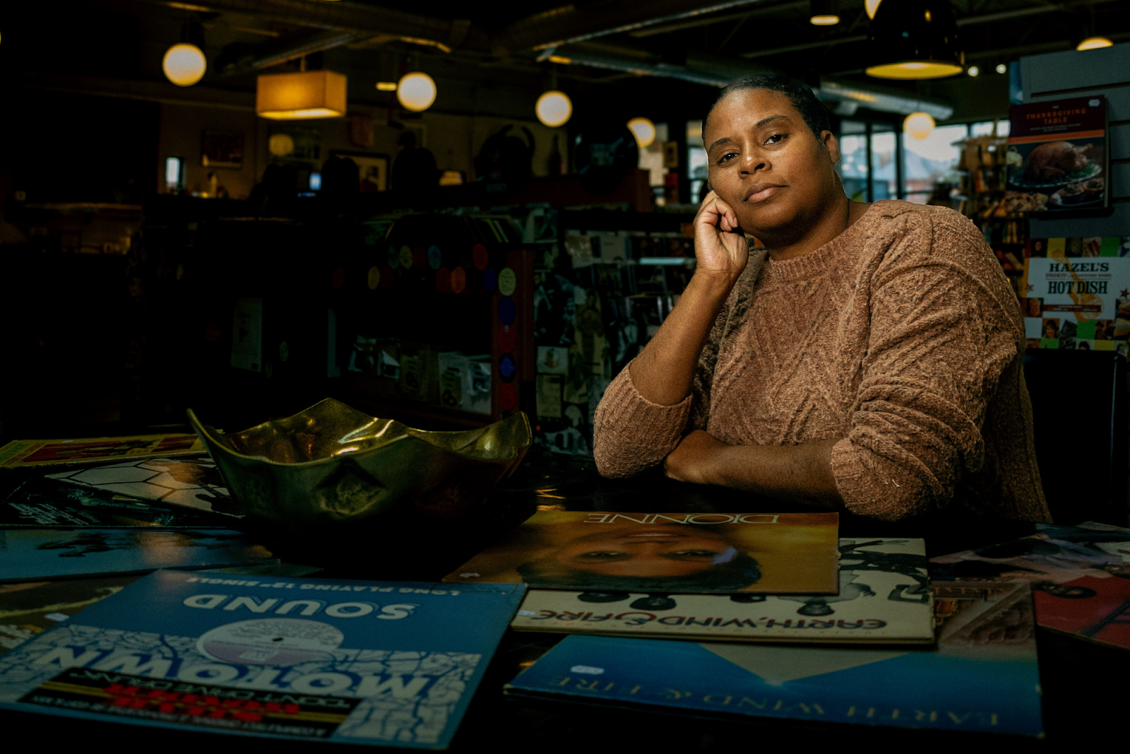 Billie Dantzler sits dignified in front of some of her favorite vinyl records inside Totem Books on Nov. 20, 2023.