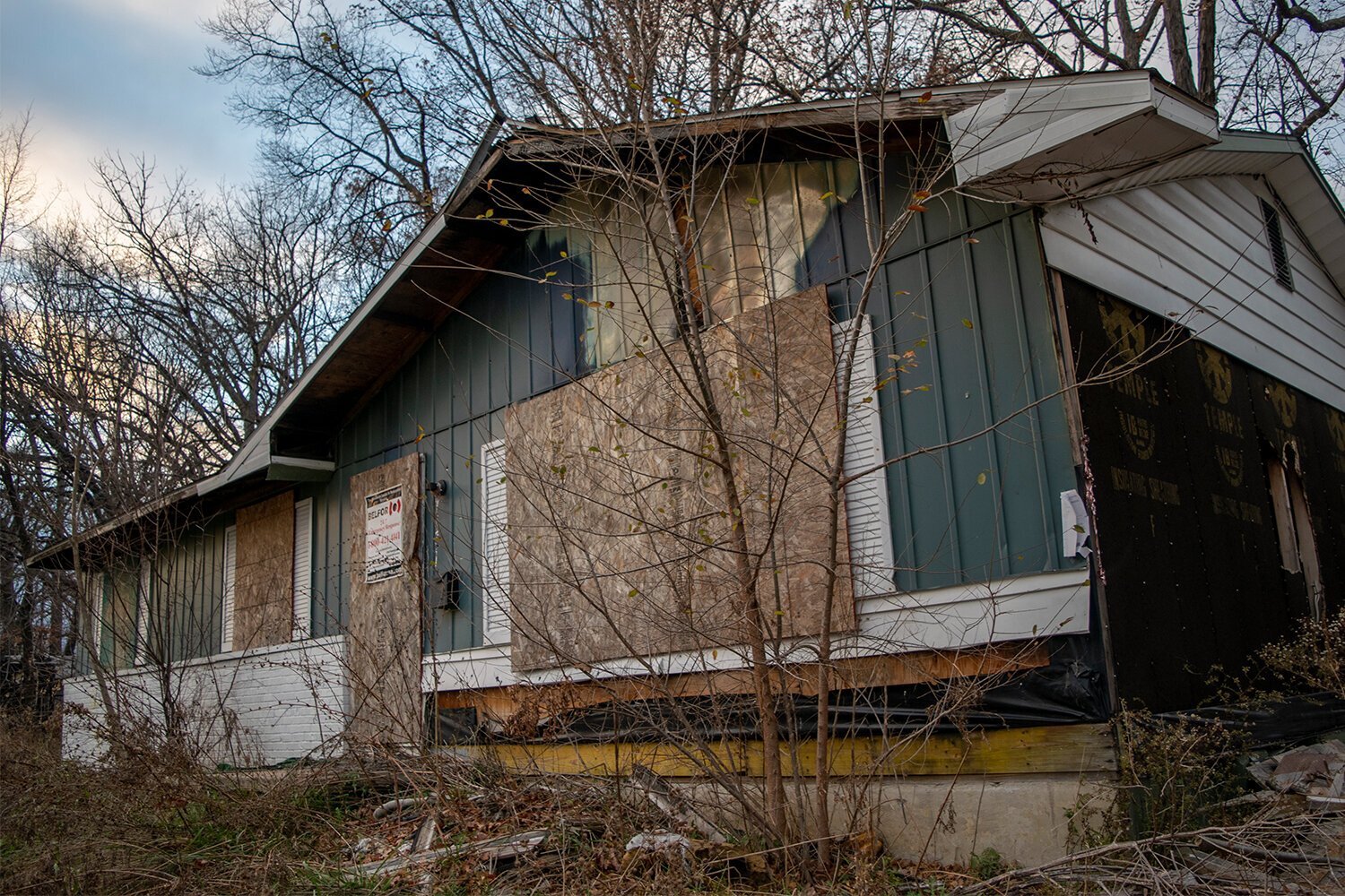 An abandoned home on Home Ave. in Flint sits vacant with the windows and front door boarded up. 