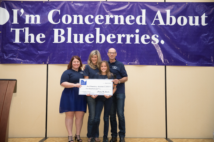 Marjory Raymer, teacher Kristie Philpott, 2017 Founder's Award winner Katie Roti, and Blueberry Founder Phil Shaltz, pose for a photo. Shaltz makes a donation to the school to honor Katie's Blueberry Moment.