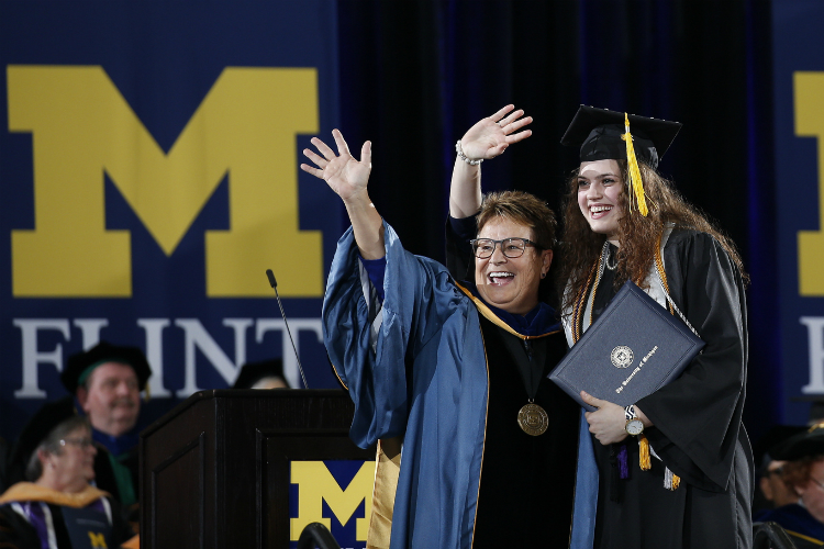 Chancellor Susan E. Borrego celebrates with a student during the December 2018 commencement.