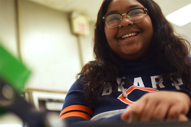 A fellow student makes a remark about McMillian being the class’ shirt queen. Her shy demeanor fades for a second as she cracks a smile. 