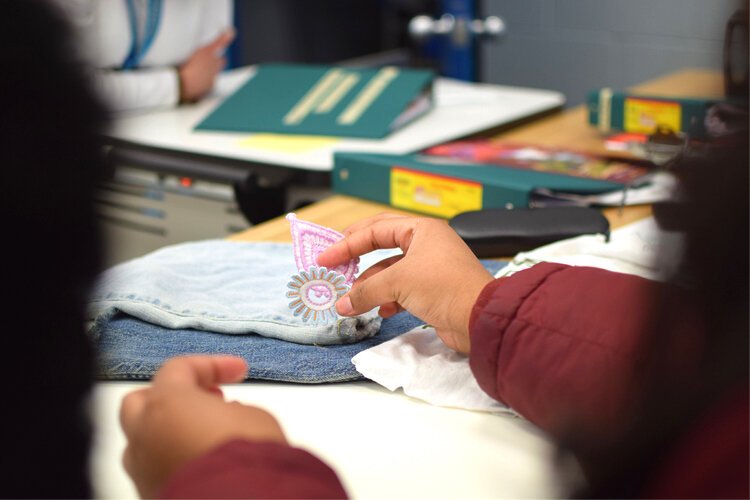 McMillian spends her time at home making small patches to sew on to blue jeans, a skill she’s just now picked up. 