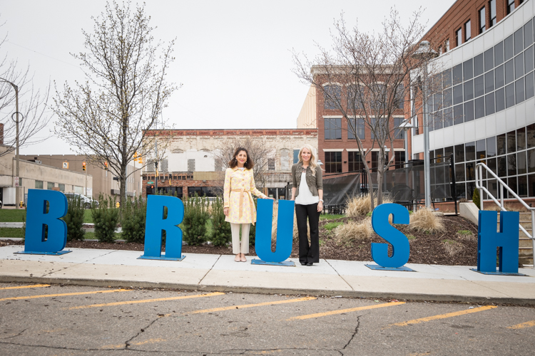 Kathleen Gazall (left) and Kristy Bearse, both members of the Friends of the Alley Committee, pose at the Brush Alley bike rack. A 30-day, $50,000 fundraising campaign to string lights in the alley kicks off on Monday, April 17, 2017.