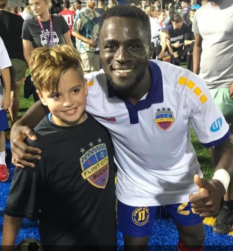 Ayuk Tambe celebrating with fans after scoring the game-winning goal in last year's national championship game.