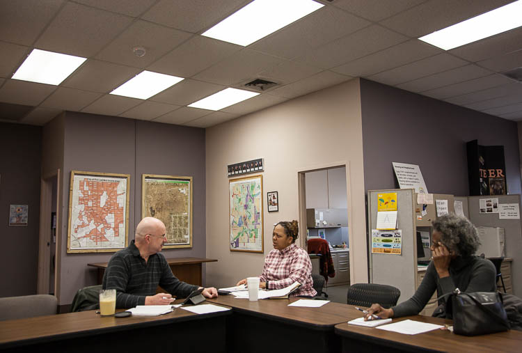 Carma Lewis meets with Chris Frye (left), treasurer of Flint Neighborhoods United, and Sandra E. Robinson, secretary of FNU during a monthly debrief meeting at the Flint Engagement Hub. 