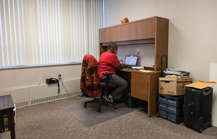 Carma Lewis works at a desk in Flint City Hall. Lewis oversees the information desk and uses the spartan space when she is there. 