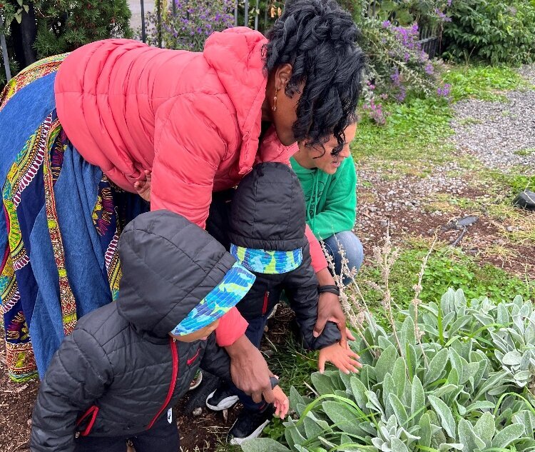 Lorna Parks, owner of House of Joy Childcare in Detroit, takes two of her children to visit the Keep Growing Detroit Garden. 