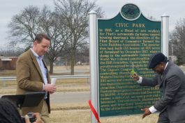 Flint City Councilman Maurice Davis cuts the ribbon at the official rededication ceremony for the Civic Park Neighborhoods historic marker. 