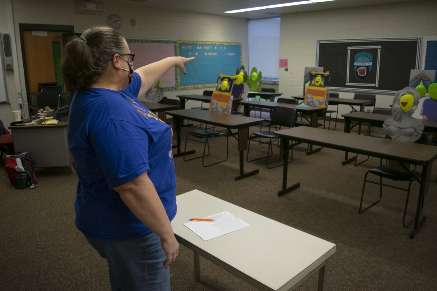 Olayinka pretends to speak to her classroom full of cardboard cutout students.