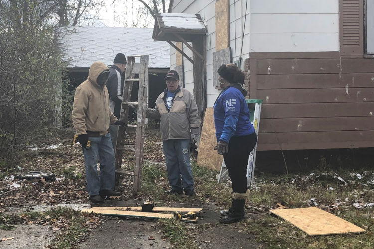 Volunteers help board up a vacant house on Flint's northside as part of a $1 million federal grant to reduce crime. 