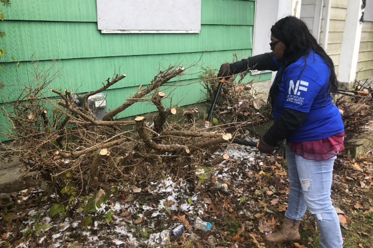 My’a Smith, a volunteer through WOW Outreach, cleans up weeds and debris at a home. "Something better for this area is possible,” she says.