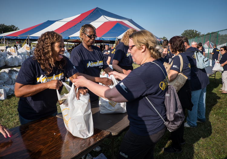 Cynthia Haynes (left) and JoAnne Hill (center) receive bags of groceries that had just been packed by volunteers at the Convoy of Hope event in Bassett Park in Flint on Saturday. Both attend Joy Taberacle in Flint and both live in the city of Flint. 