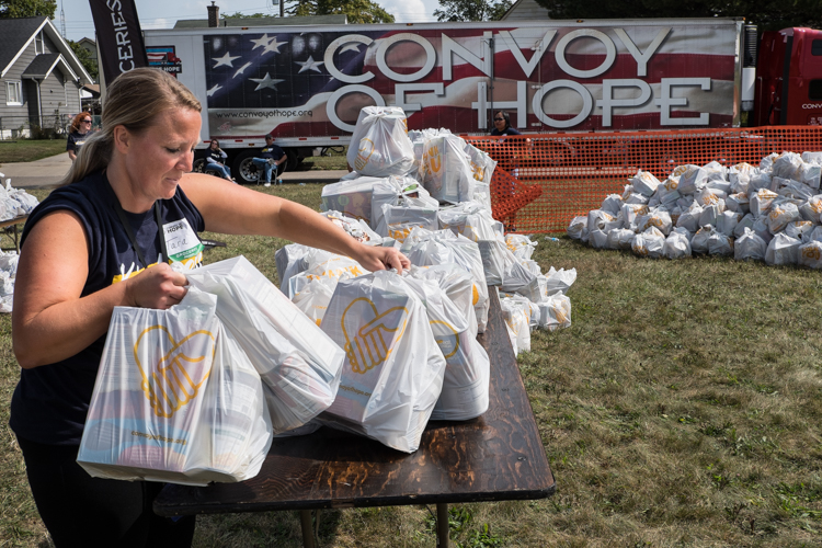 Tara Stimson of Davison Twp. organizes bags of groceries at the Convoy of Hope event in 2017