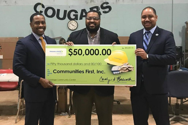 LeeRoy Wells Jr., vice president of operations support for Consumers Energy; Glenn WIlson, president and CEO Communities First Inc.; and Kyle McCree, community affairs area manager for Consumers pose with a check that will fund the Coolidge Community