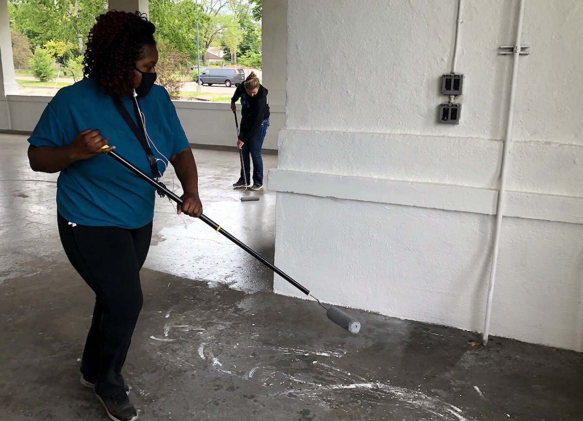 Ladel Lewis, second ward, and Allie Herkenroder, seventh ward, helped paint the floor at the Kearsley Park pavilion in May.