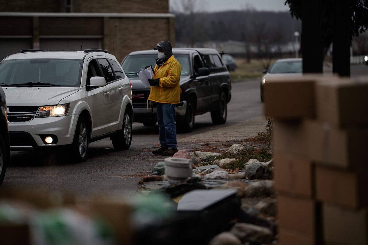 Deacon Omar Odette directs traffic at Holy Redeemer as families drive through the food and gift donation line.