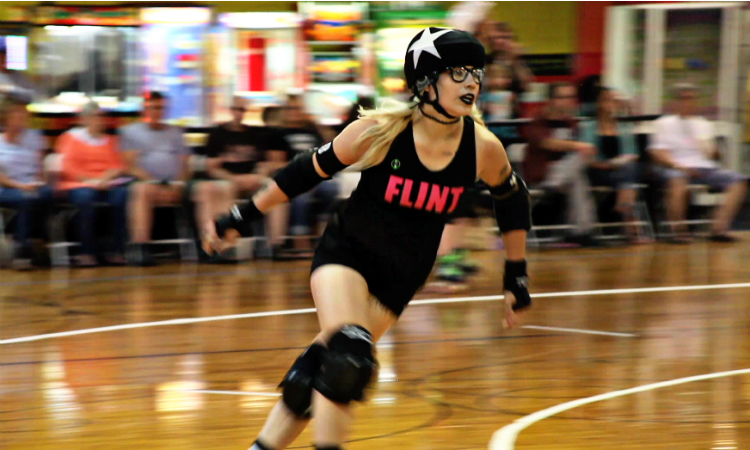 Ashley MacDermaid, aka, Ash Tray, races out of the pack past opponent blockers, becoming the lead jammer for the Flint City Derby Girls. The lead jammer can also end scoring against the opposing teams jammer during a two minute round.