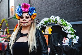 Juliza Murillo, originally from Jalisco, Mexico, poses for a portrait during the Latinx Technology and Community Center's Dia de Los Muertos celebration on Wednesday, Nov. 2, 2022 in downtown Flint.