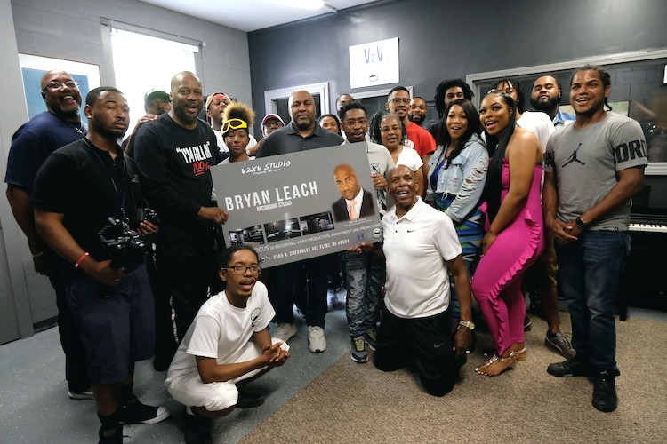 Pastor McCathern of Joy Tabernacle (from bottom right), Bryan Leach (middle), and Paster Daren C. Jaime of People's AME Church (left) pose with several local showcase talents after the renaming and rededication of the V2xV studio.