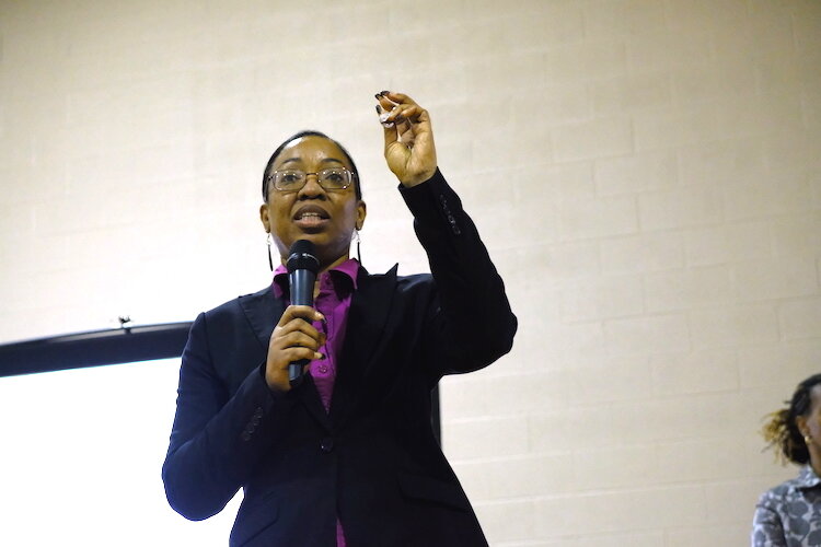 Sandra Carr demonstrates the size of her tracking technology for her Digital Imaging Tracking System presentation for 100k Ideas' Pitch for $K event.