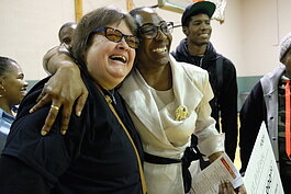 Linda Bell embraces her longtime friend Nancy Jago (a deaf and blind community member) after her $10,000 win.