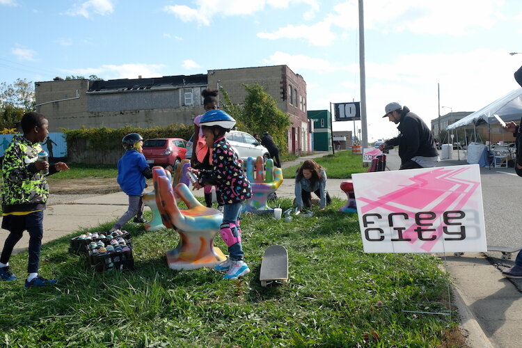 Children get a chance to spray paint some chairs during the Free City Mural Festival.