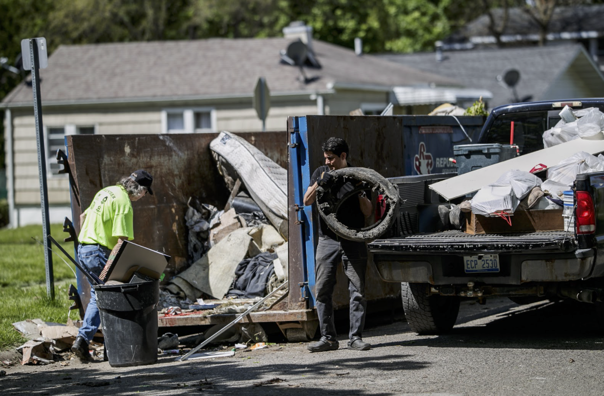 Dr. Bobby Mukkamala helps load trash into a dumpster in the Eastside Franklin Park Neighborhood on May 15.