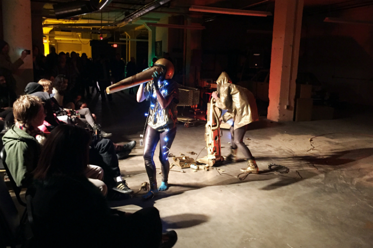 Cinthia Montague (left foreground) and Candice Stewart work the stage for their performance art set at the soft opening for Factory Two in downtown Flint.