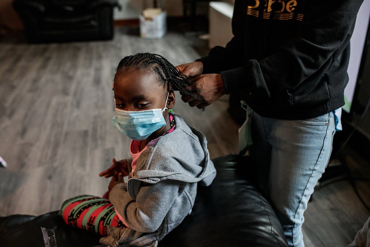 Chanelle Hodo, 26, a resident of Shelter of Flint, beads her daughter's hair.