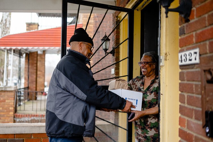 Meals on Wheels driver Lamar Ellington gives Beverly Sullivan, 79, a meal delivery for her mom, Ellen Dennis, 97.