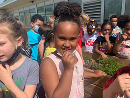 A Minges Brook Elementary student tastes herbs from the school garden planted by students.