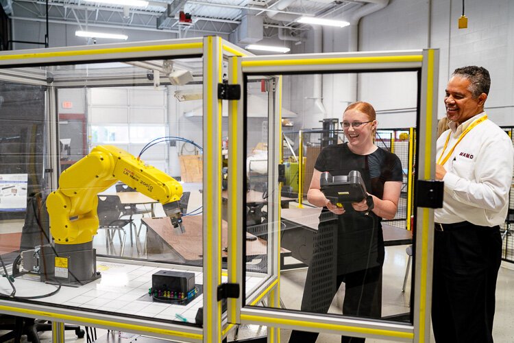 Cleveland Sparrow (right) with a student working with a robot.