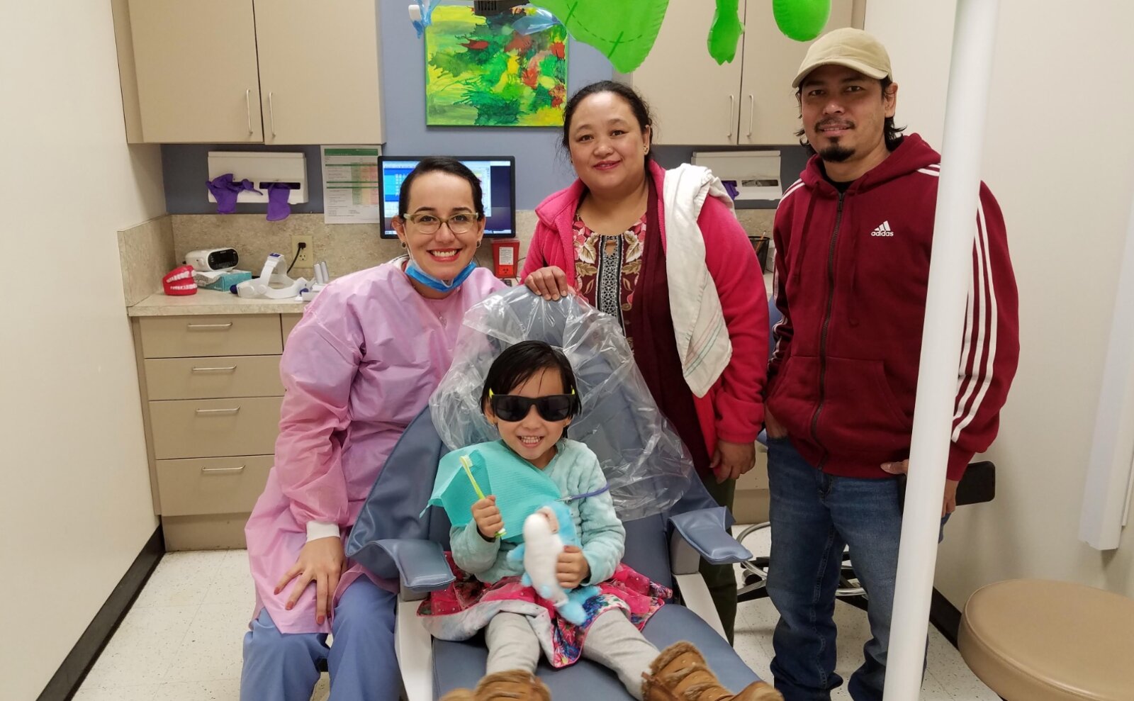 A young patient with his parents at the Cincinnati Health Department following a dental checkup.