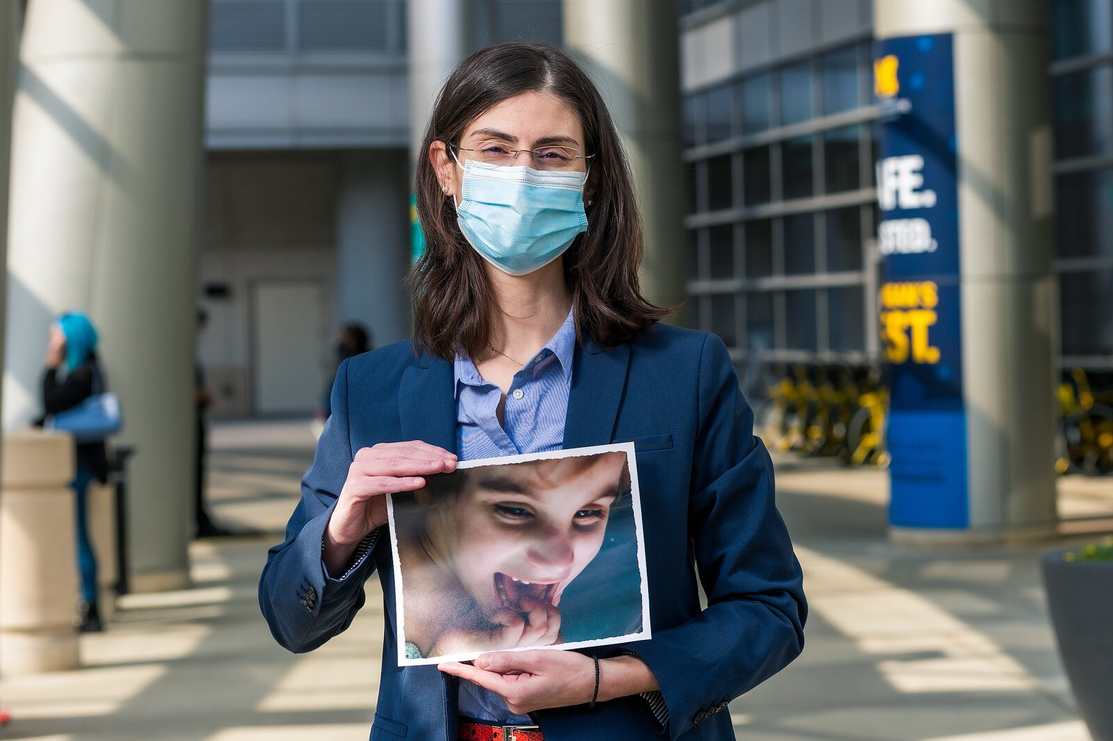 End-of-life doula Toula Saratsis holds a photo of her daughter Angelica, who died at age 7 of a rare genetic disorder.