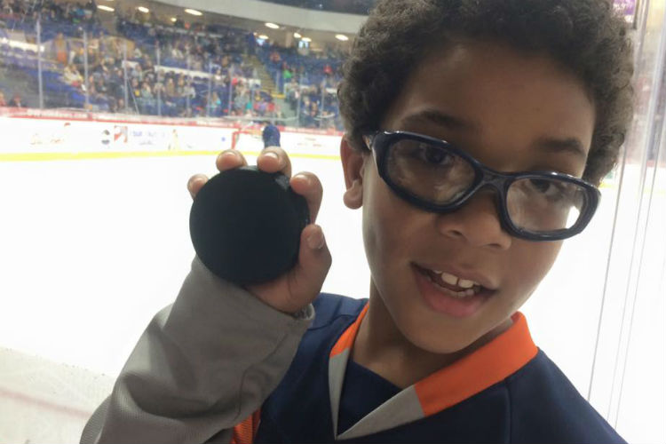 Kid One shows off the game puck he was randomly given.