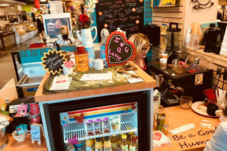 Stephanie Norman, owner at Hot Cups in the Flint Farmer's Market talks describes her signature drinks to a customer. Norman has been serving coffee at the market for the last four years.