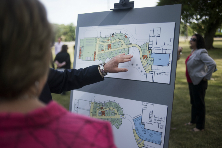 Liz Murphy of the Flint & Genesee Chamber looks over floor  Flint Cultural Center Academy plans. 