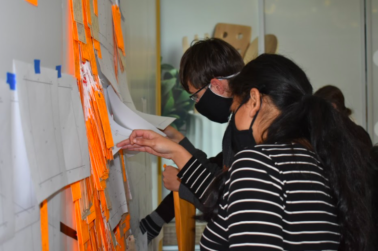 Students work together to install the Hostile Terrain 94 (HT94) exhibit on display at Flint Farmers' Market.